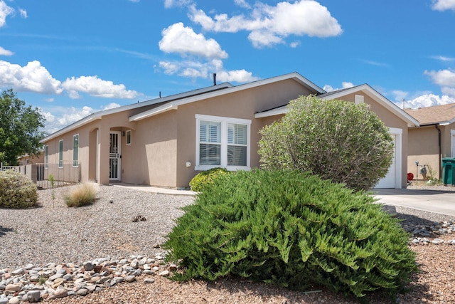 3758 Cattle Dr NE, Rio Rancho, NM 87144 - view of side of home featuring stucco siding, an attached garage, and driveway