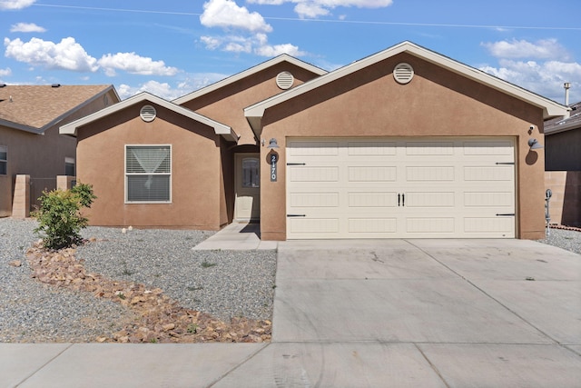 2170 Firewheel Ave SW, Los Lunas, NM 87031 - ranch-style home featuring a garage, driveway, and stucco siding