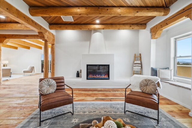 30A Arroyo Coyote Rd, Santa Fe, NM 87508 - living area with a wood ceiling with exposed beams, hardwood / wood-style flooring, and a large fireplace