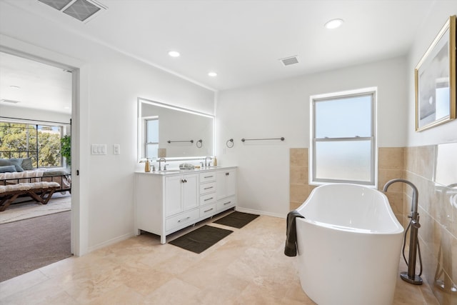 30A Arroyo Coyote Rd, Santa Fe, NM 87508 - ensuite bathroom with double vanity, a freestanding tub, and recessed lighting