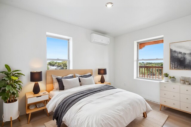 30A Arroyo Coyote Rd, Santa Fe, NM 87508 - bedroom featuring a wall mounted AC and light wood-style flooring