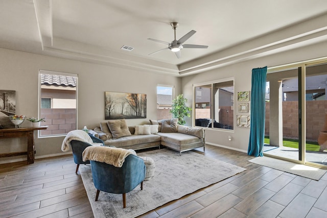 9035 S Sky St NW, Albuquerque, NM 87114 - living room featuring a raised ceiling, ceiling fan, wood finished floors, and baseboards