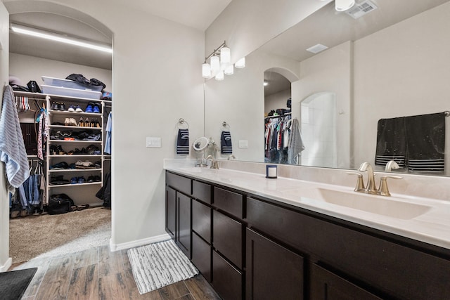 9035 S Sky St NW, Albuquerque, NM 87114 - bathroom with wood finished floors, double vanity, a spacious closet, and baseboards