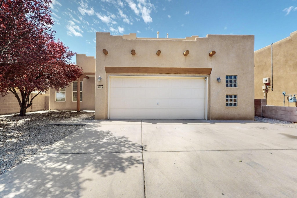 5112 Stone Mountain Rd NW, Albuquerque, NM 87114 - pueblo revival-style home featuring stucco siding, driveway, and a garage