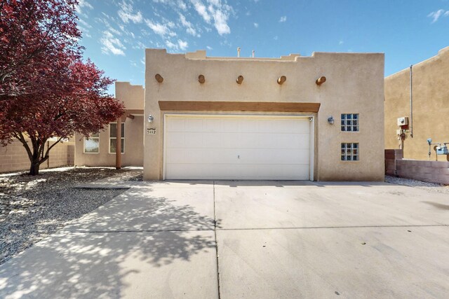 5112 Stone Mountain Rd NW, Albuquerque, NM 87114 - pueblo revival-style home featuring stucco siding, driveway, and a garage