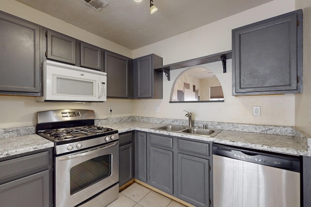 2815 Quail Pointe Dr NW, Albuquerque, NM 87120 - kitchen with appliances with stainless steel finishes, a sink, light countertops, and light tile patterned floors
