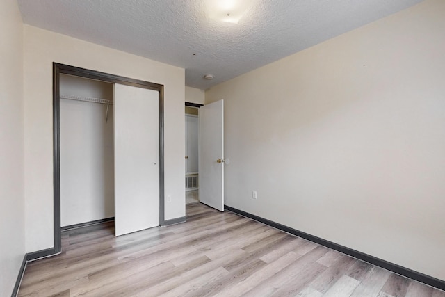2815 Quail Pointe Dr NW, Albuquerque, NM 87120 - unfurnished bedroom featuring light wood finished floors, baseboards, a closet, and a textured ceiling