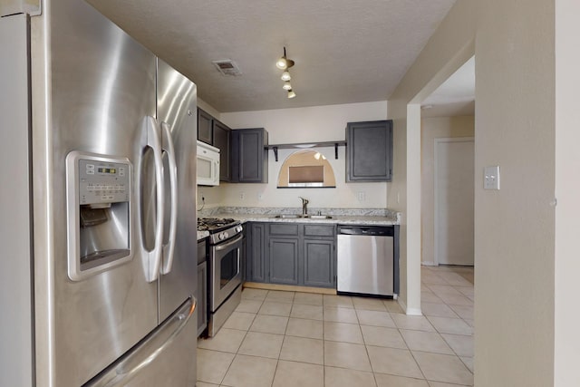 2815 Quail Pointe Dr NW, Albuquerque, NM 87120 - kitchen featuring appliances with stainless steel finishes, a sink, light tile patterned floors, and baseboards