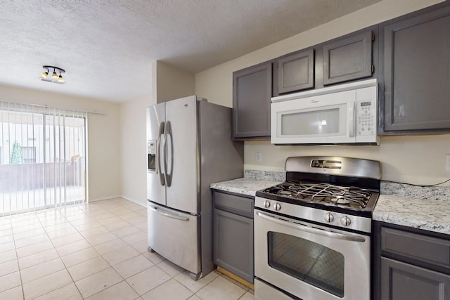2815 Quail Pointe Dr NW, Albuquerque, NM 87120 - kitchen featuring appliances with stainless steel finishes, a textured ceiling, light tile patterned floors, and gray cabinets