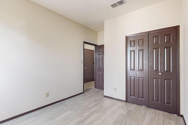 1375 Golden Eye Loop NE, Rio Rancho, NM 87144 - unfurnished bedroom with light wood-type flooring, baseboards, and a closet