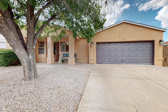 1375 Golden Eye Loop NE, Rio Rancho, NM 87144 - view of front facade with stucco siding, concrete driveway, an attached garage, and a porch
