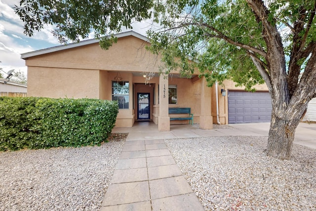 1375 Golden Eye Loop NE, Rio Rancho, NM 87144 - view of front of home featuring stucco siding, covered porch, a garage, and concrete driveway
