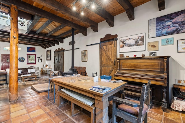 4 Pop Chalee, Glorieta, NM 87535 - dining room featuring wooden ceiling with exposed beams, a wood stove, a barn door, and stone tile flooring
