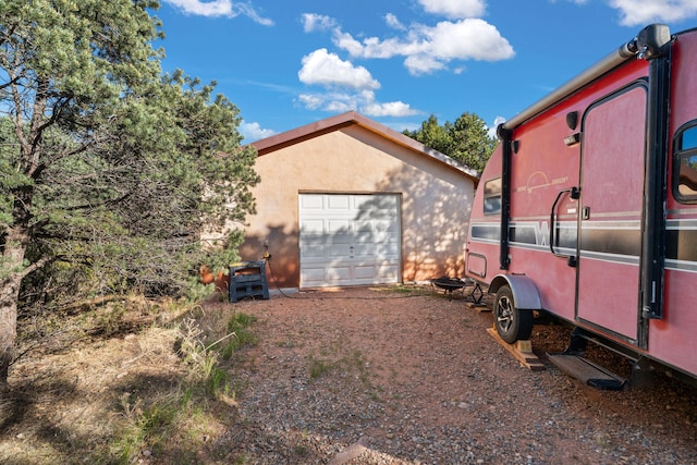 4 Pop Chalee, Glorieta, NM 87535 - view of side of property featuring dirt driveway, an outdoor structure, and a garage
