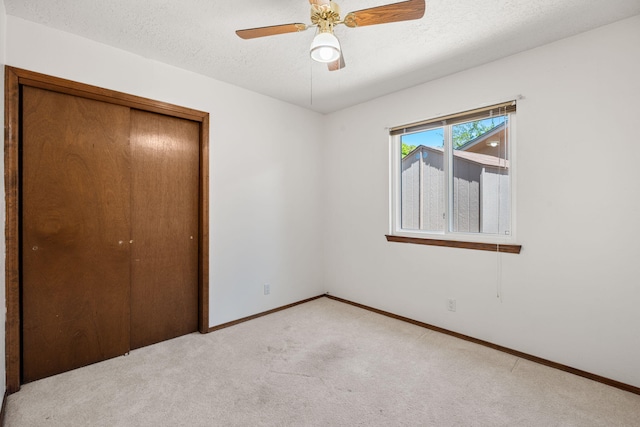 7401 Volunteer St NE, Albuquerque, NM 87109 - unfurnished bedroom featuring light carpet, a closet, baseboards, a textured ceiling, and ceiling fan
