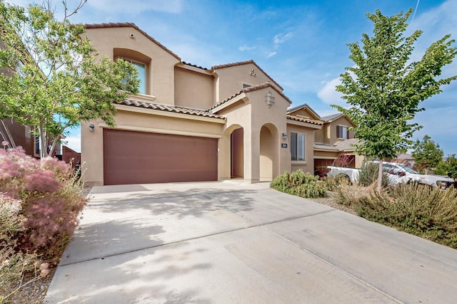 3034 Shannon Ln NE, Rio Rancho, NM 87144 - mediterranean / spanish home featuring stucco siding, driveway, a tiled roof, and an attached garage