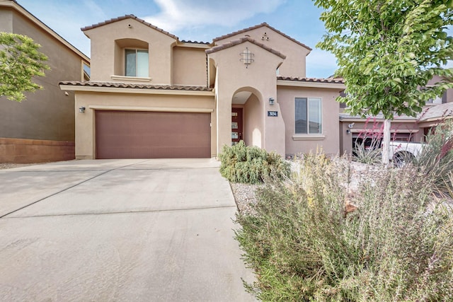 3034 Shannon Ln NE, Rio Rancho, NM 87144 - mediterranean / spanish-style home featuring stucco siding, a tiled roof, concrete driveway, and a garage