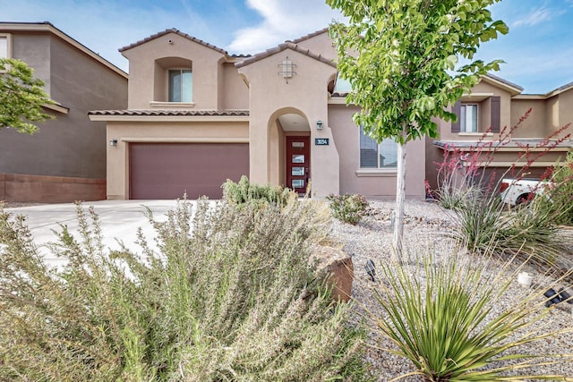 3034 Shannon Ln NE, Rio Rancho, NM 87144 - mediterranean / spanish house featuring a tile roof, stucco siding, an attached garage, and concrete driveway