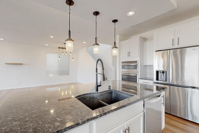 3034 Shannon Ln NE, Rio Rancho, NM 87144 - kitchen with stainless steel appliances, a sink, white cabinets, light wood-type flooring, and recessed lighting