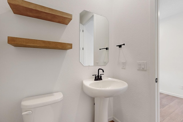3034 Shannon Ln NE, Rio Rancho, NM 87144 - half bath featuring toilet, wood finished floors, baseboards, and a sink