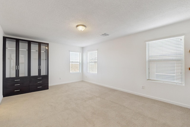 3034 Shannon Ln NE, Rio Rancho, NM 87144 - unfurnished bedroom featuring light colored carpet, a textured ceiling, and baseboards