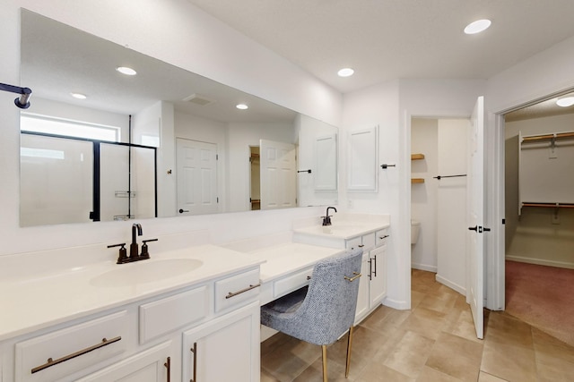 3034 Shannon Ln NE, Rio Rancho, NM 87144 - bathroom featuring double vanity, recessed lighting, toilet, a walk in closet, and tile patterned flooring
