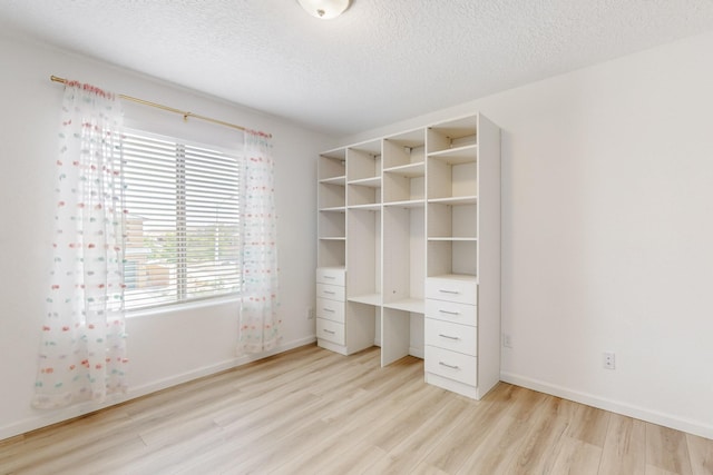 3034 Shannon Ln NE, Rio Rancho, NM 87144 - unfurnished bedroom with light wood-type flooring, a textured ceiling, and baseboards