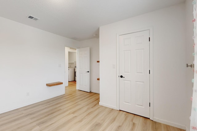 3034 Shannon Ln NE, Rio Rancho, NM 87144 - unfurnished bedroom with light wood-type flooring, washer / dryer, and baseboards