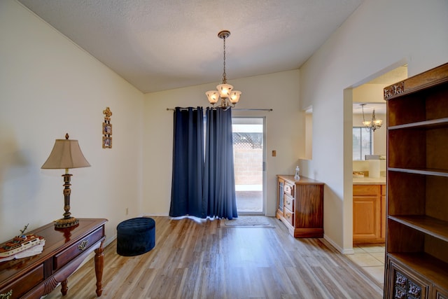 2575 Diamond Peak Dr NE, Rio Rancho, NM 87144 - foyer with a chandelier, vaulted ceiling, light wood finished floors, and baseboards