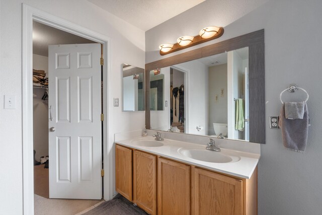 6308 Turquoise Trl NE, Rio Rancho, NM 87144 - bathroom featuring double vanity, toilet, and a walk in closet