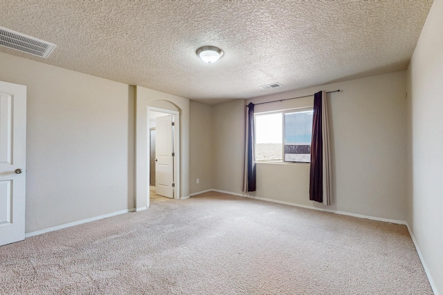 221 Landing Trl, Rio Rancho, NM 87124 - spare room featuring light carpet, arched walkways, baseboards, and a textured ceiling
