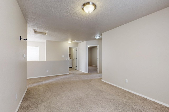 221 Landing Trl, Rio Rancho, NM 87124 - empty room with a textured ceiling, light colored carpet, baseboards, washer / dryer, and attic access