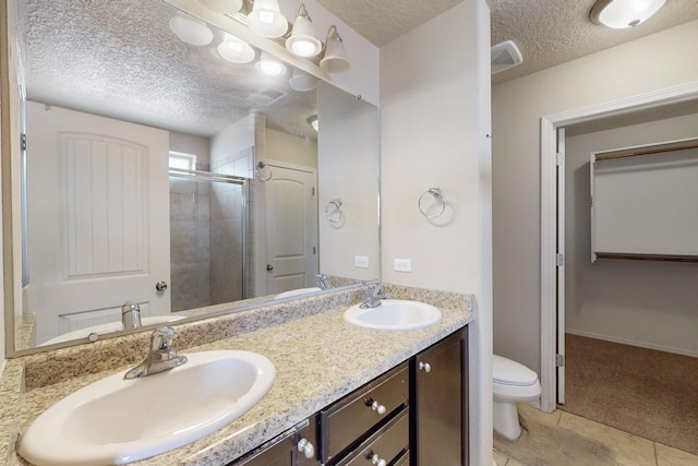 221 Landing Trl, Rio Rancho, NM 87124 - full bathroom featuring a textured ceiling, toilet, a stall shower, double vanity, and tile patterned floors