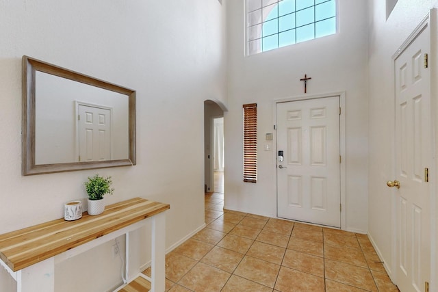 1034 Wagon Trail St, Los Lunas, NM 87031 - entryway featuring arched walkways, a high ceiling, and light tile patterned flooring