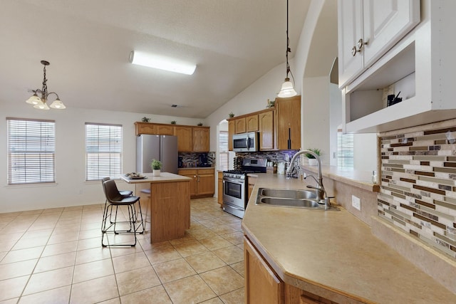 1034 Wagon Trail St, Los Lunas, NM 87031 - kitchen with stainless steel appliances, tasteful backsplash, light countertops, a kitchen island, and pendant lighting
