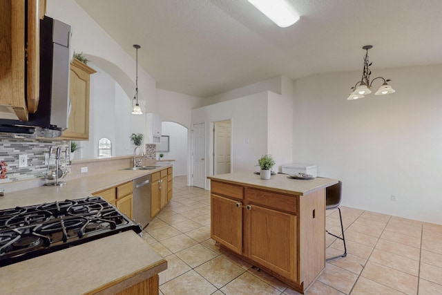 1034 Wagon Trail St, Los Lunas, NM 87031 - kitchen with arched walkways, stainless steel dishwasher, light tile patterned floors, tasteful backsplash, and light countertops