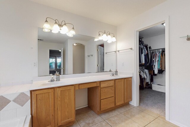 1034 Wagon Trail St, Los Lunas, NM 87031 - bathroom featuring double vanity, tile patterned flooring, a walk in closet, and a tub to relax in