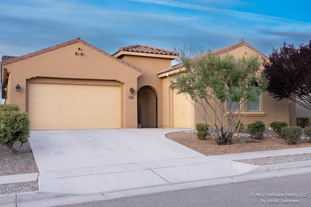 8704 Espacio Verde Rd, Albuquerque, NM 87120 - mediterranean / spanish-style home featuring stucco siding, an attached garage, and concrete driveway