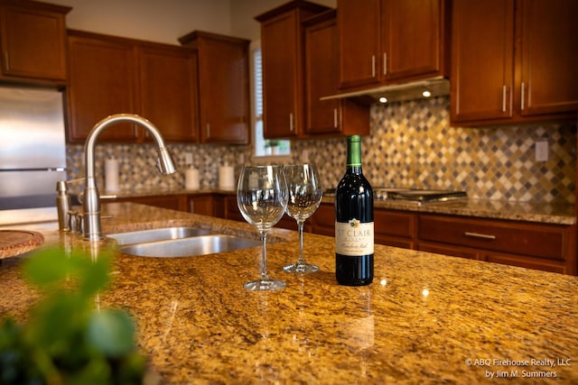 8704 Espacio Verde Rd, Albuquerque, NM 87120 - kitchen featuring stainless steel fridge, under cabinet range hood, decorative backsplash, and a sink