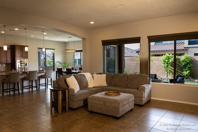 8704 Espacio Verde Rd, Albuquerque, NM 87120 - living area with arched walkways, dark tile patterned floors, recessed lighting, and a textured ceiling