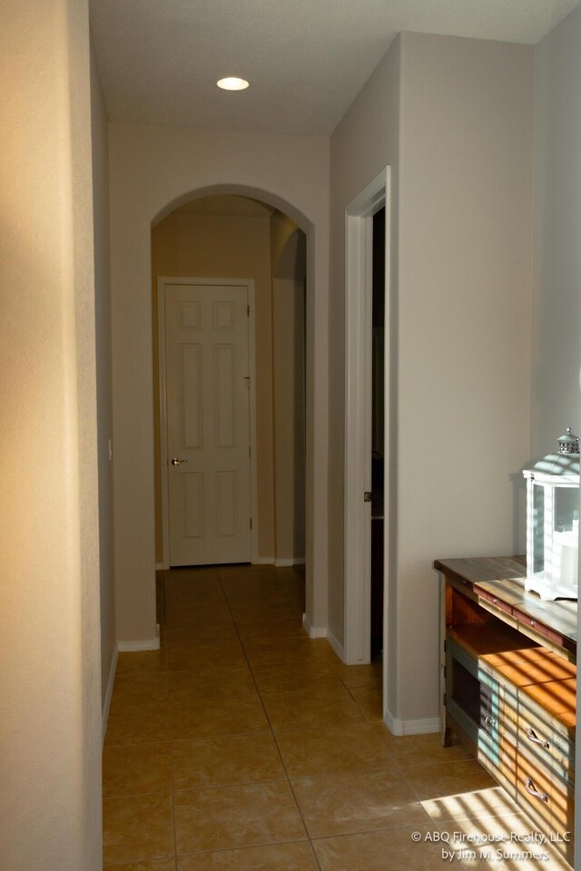 8704 Espacio Verde Rd, Albuquerque, NM 87120 - hallway with arched walkways, light tile patterned flooring, baseboards, and recessed lighting