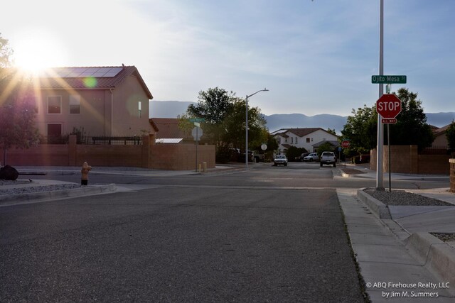 8704 Espacio Verde Rd, Albuquerque, NM 87120 - view of asphalt street with traffic signs, sidewalks, curbs, and a mountain view