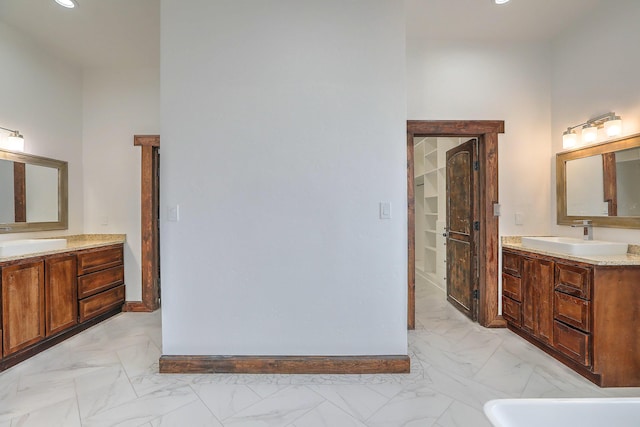 1209 11th St SE, Rio Rancho, NM 87124 - full bathroom with marble finish flooring, two vanities, baseboards, a tub, and recessed lighting