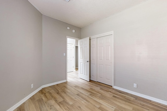 10809 Academy Ridge Rd NE, Albuquerque, NM 87111 - unfurnished bedroom with light wood finished floors, baseboards, and a closet