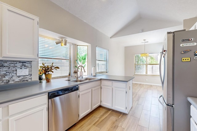 10809 Academy Ridge Rd NE, Albuquerque, NM 87111 - kitchen with appliances with stainless steel finishes, a sink, vaulted ceiling, white cabinets, and a peninsula