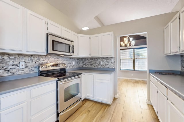 10809 Academy Ridge Rd NE, Albuquerque, NM 87111 - kitchen featuring appliances with stainless steel finishes, tasteful backsplash, a chandelier, white cabinetry, and light wood-style flooring