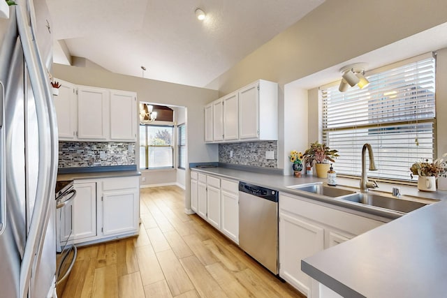 10809 Academy Ridge Rd NE, Albuquerque, NM 87111 - kitchen featuring appliances with stainless steel finishes, a sink, white cabinetry, and vaulted ceiling
