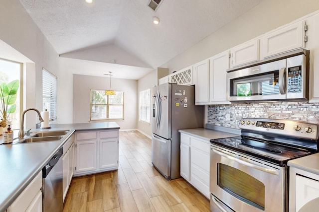 10809 Academy Ridge Rd NE, Albuquerque, NM 87111 - kitchen with stainless steel appliances, a sink, white cabinets, lofted ceiling, and tasteful backsplash