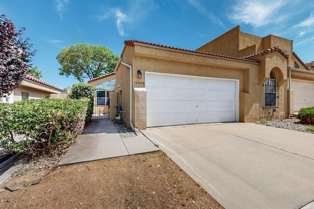 10809 Academy Ridge Rd NE, Albuquerque, NM 87111 - view of front facade with stucco siding, a garage, a gate, and concrete driveway