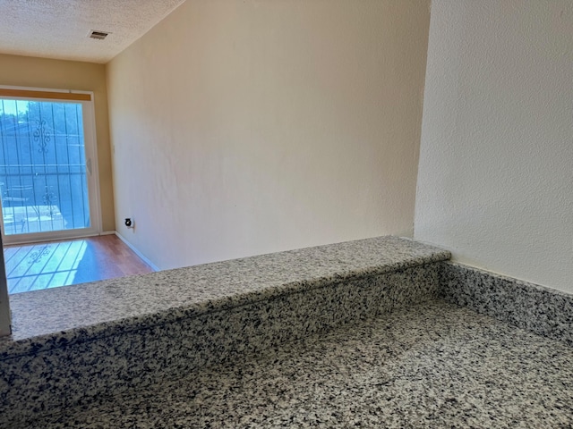 774 Stallion Rd SE, Rio Rancho, NM 87124 - empty room featuring plenty of natural light, a textured ceiling, and wood finished floors